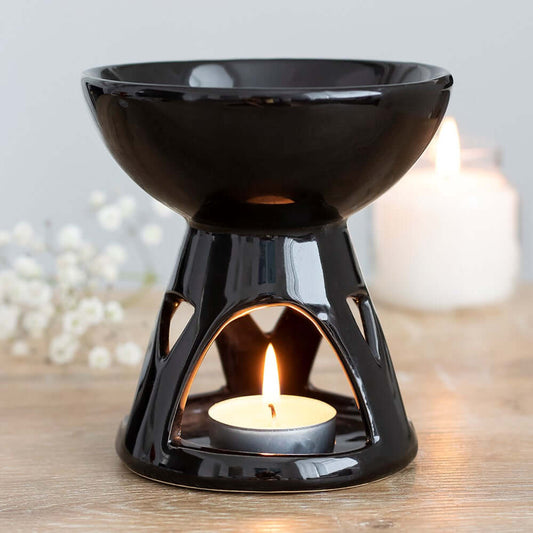 Tea Light Wax Melt Burner in Use – A lit black ceramic burner with a tea light and melting wax for home fragrance.