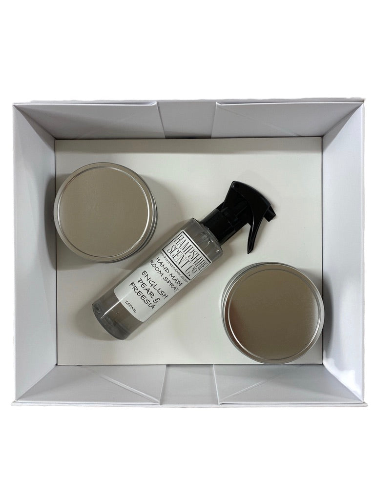 "Open luxury gift box displaying two handmade soy wax tin candles and one room spray nestled in bespoke inlay."