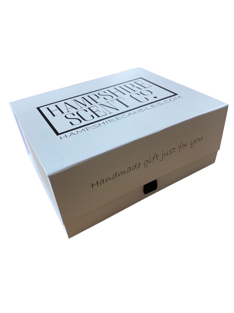 Close-up of handmade soy wax tin candles from Hampshire Candles with elegant labels and eco-friendly design.