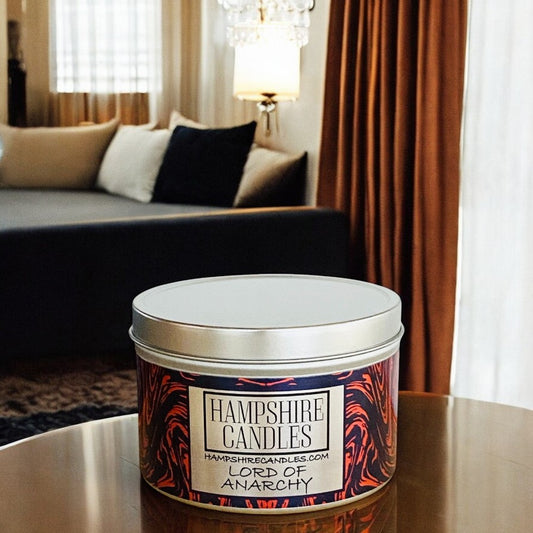 A scented tin candle labeled "Lord of Anarchy," hand-poured in Hampshire with a bold fragrance of patchouli, peppercorn, black pepper, and vanilla pods.