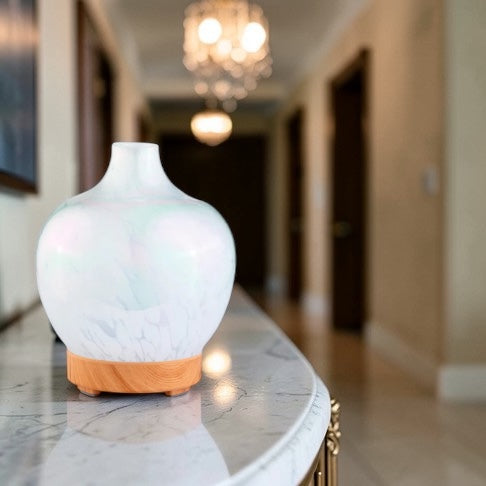 white essential oil diffuser in bedroom creating relaxing aromatherapy atmosphere