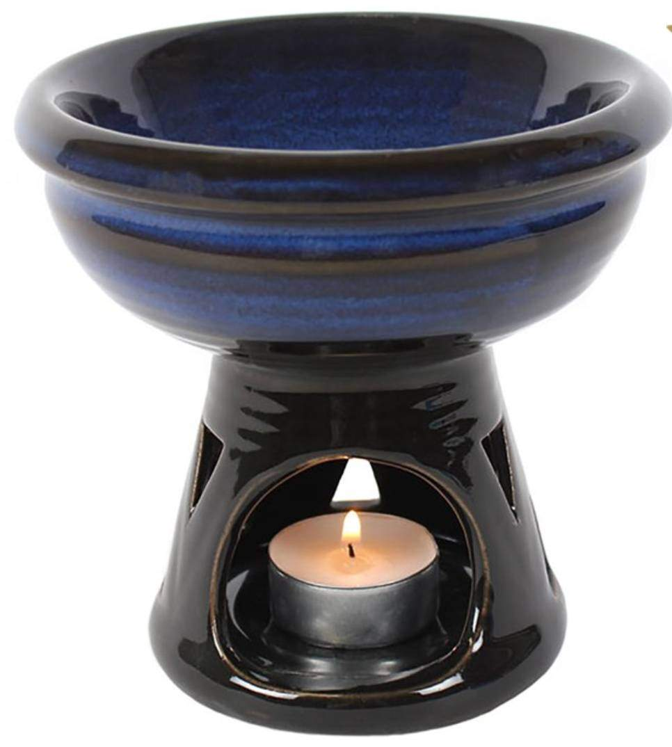 Tea Light Wax Melt Burner in Use – A lit dark blue ceramic burner with a tea light and melting wax for home fragrance.