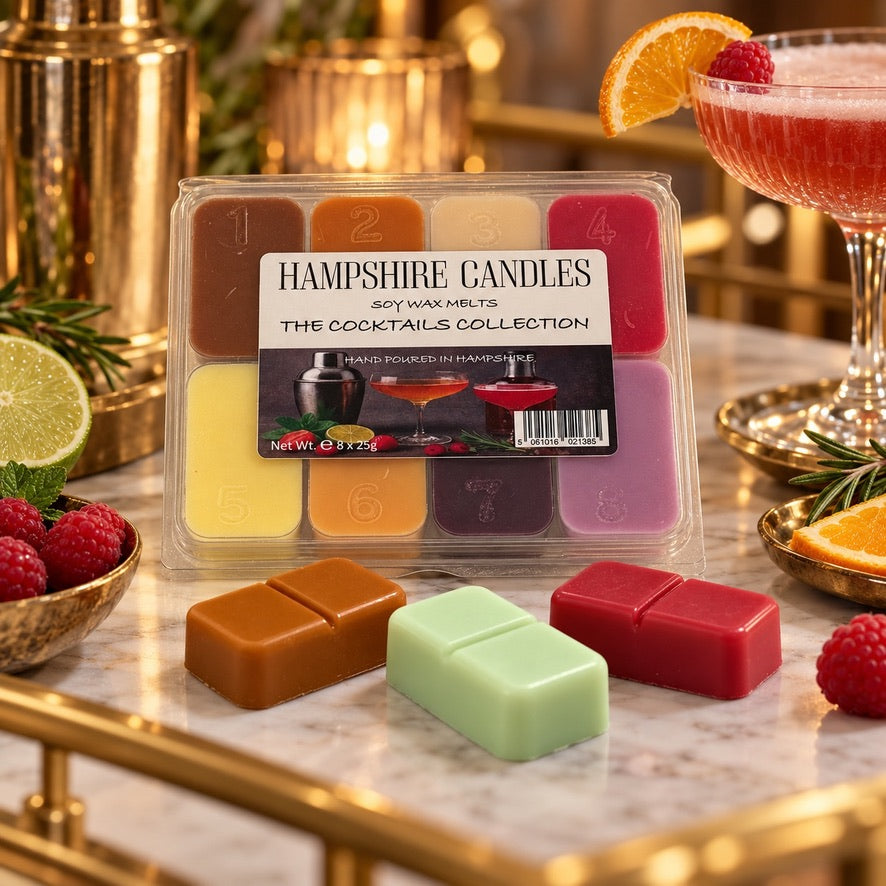 Cocktails Collection selection box on a bar with a pink cocktail glass, lime, raspberries and three loose snap melts