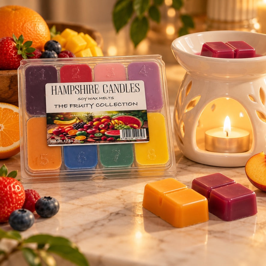 Fruity Collection soy wax melts by a lit white tealight burner with strawberries, blueberries and orange and red melts