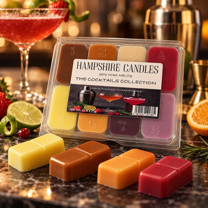 Cocktails Collection gift box on a dark bar top with a cocktail shaker, lime wedges and yellow, brown, orange and red melts