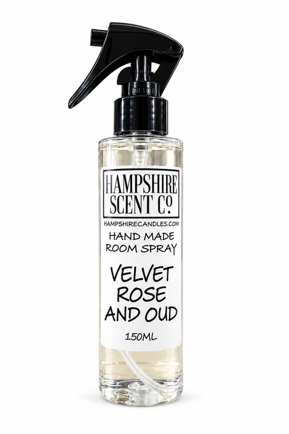 A 150ml clear room spray bottle with a black trigger spray cap, featuring a white label for Hampshire Scent Co. 'Velvet Rose and Oud' scent.