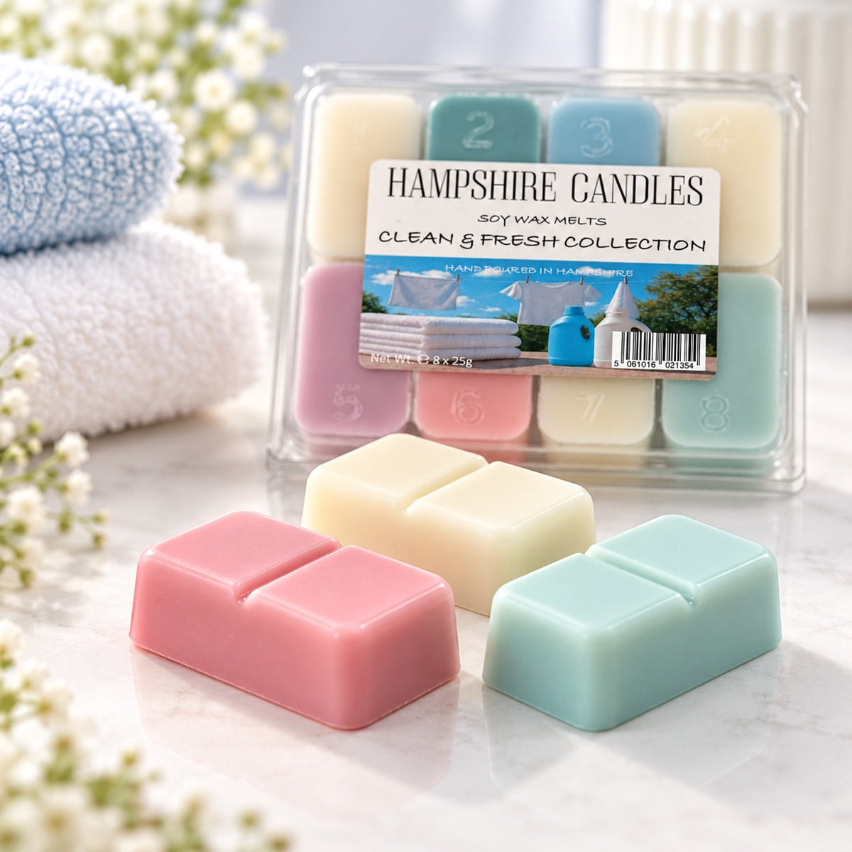 Clean & Fresh Collection wax melt box with loose pink, cream and sage green snap melts, soft towels and white flowers