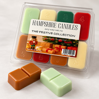 Festive Collection wax melt gift box angled on white, with a caramel melt and a pale green melt in the foreground