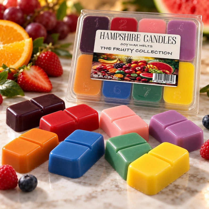 Fruity Collection wax melt gift box with eight colourful snap melts laid out in front among strawberries and orange slices