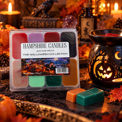 Halloween Collection Box soy wax melts beside a lit black pumpkin wax burner, surrounded by pumpkins, candles and autumn leaves