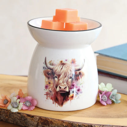 Close-up of Highland Cow wax melt burner showing the gentle cow face, colourful floral accents and smooth white ceramic finish.