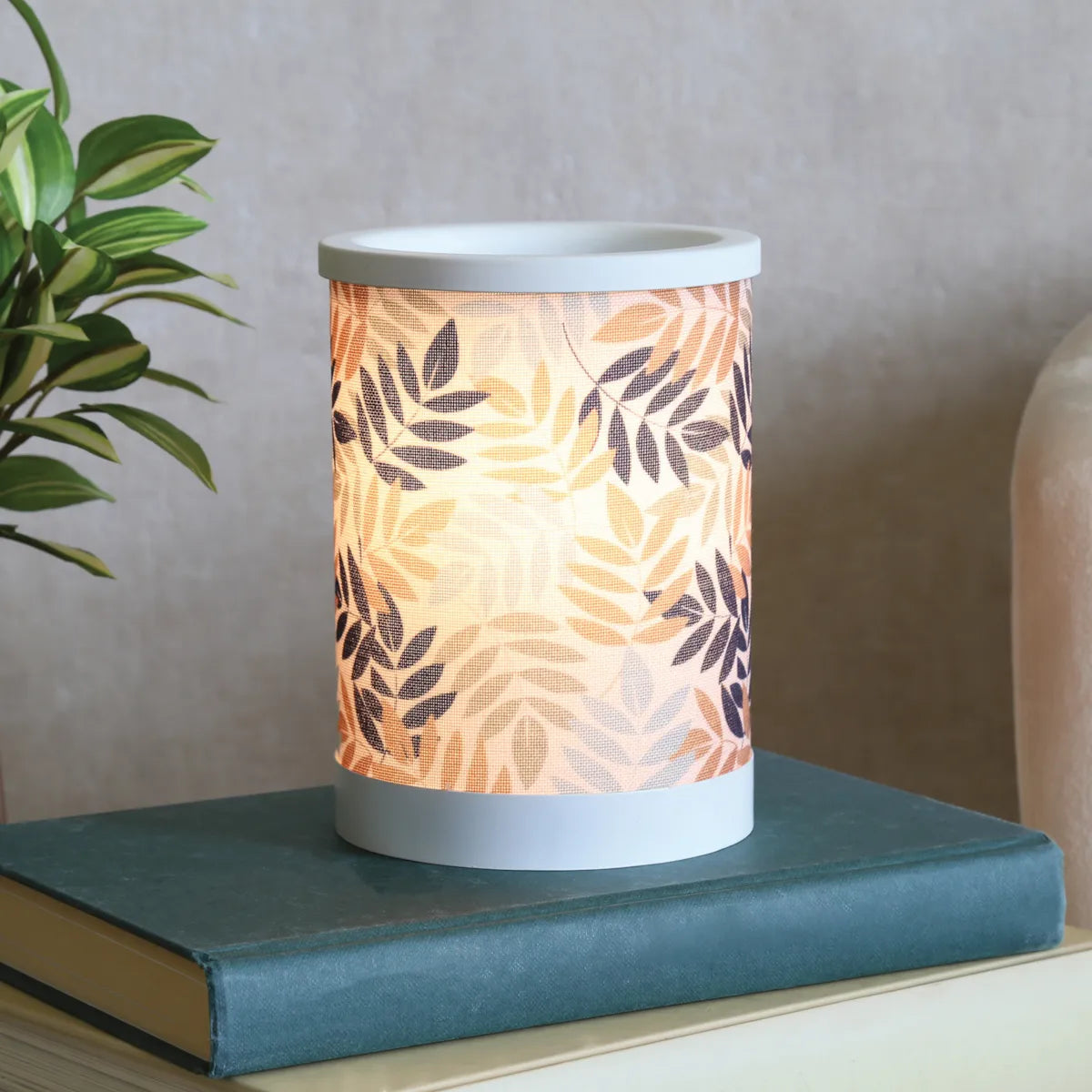 Close-up of the Leaves Electric Wax Warmer showing intricate leaf design and warm ambient lighting.