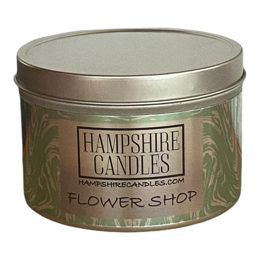 A soy wax candle tin in Flower Shop scent, featuring a lush and fresh floral fragrance inspired by a blooming garden.