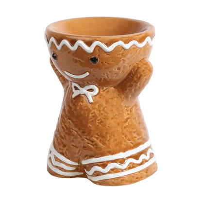 Gingerbread Man tealight wax melt burner displayed with festive Christmas décor while warming scented wax melts in the top dish.
