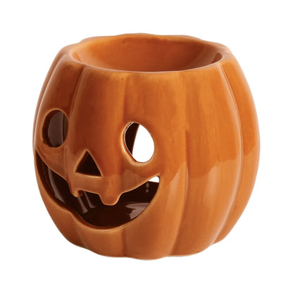 Orange Pumpkin tealight wax melt burner glowing in a cosy autumn home while gently warming scented soy wax melts.