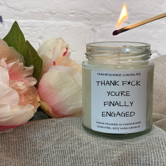 Gift-ready packaging of “THANK F** YOU’RE FINALLY ENGAGED”* scented candle.
