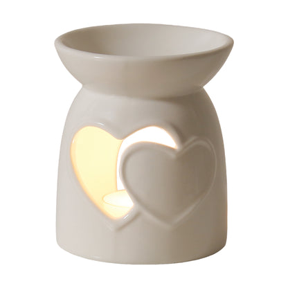 Two hearts ceramic wax warmer with a lit tealight glowing through the heart cut-out